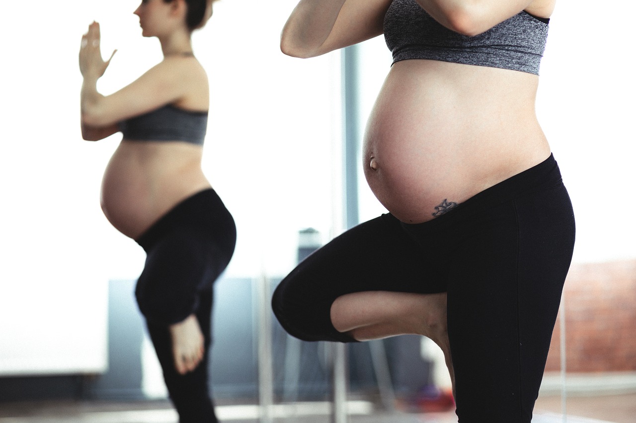 Zwangere vrouw doet yoga oefening.
